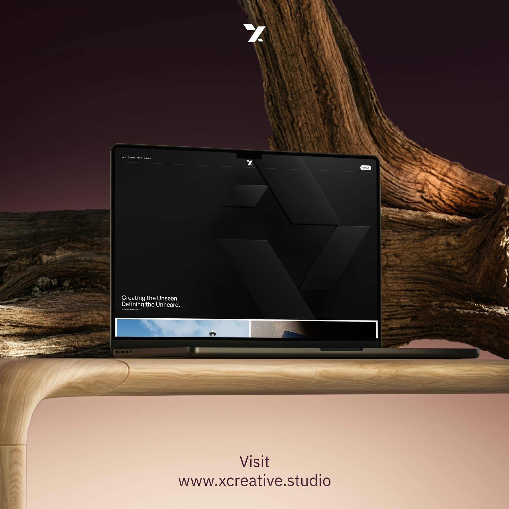 A laptop showing Shafeay Group work, set against a weathered tree
