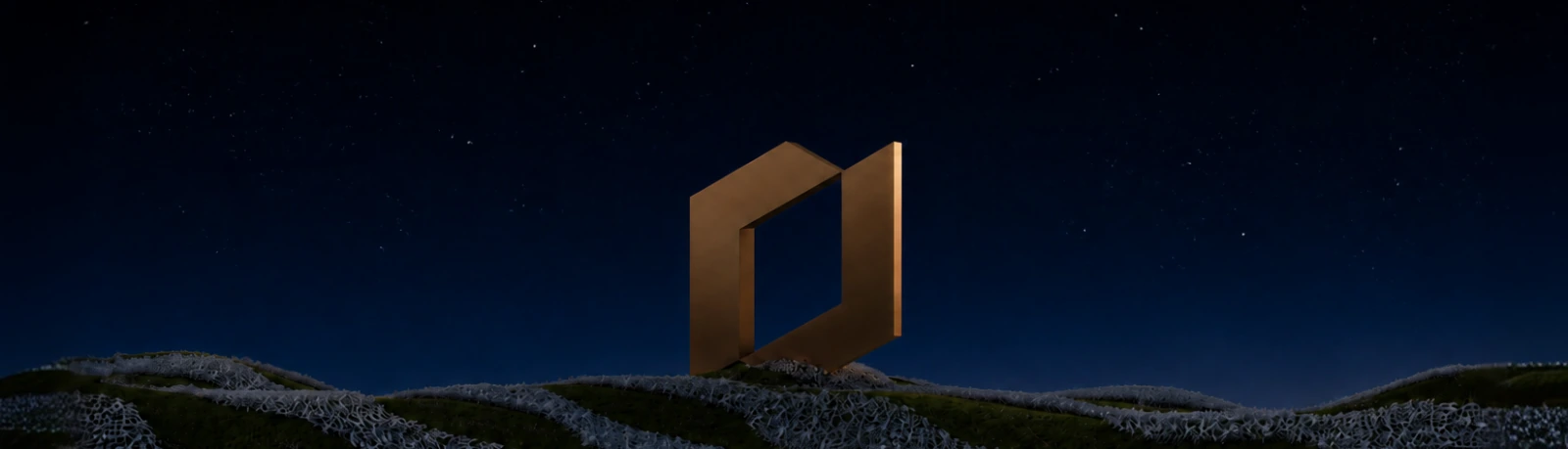 The bronze Shafeay monument lit against a night sky over dark hills